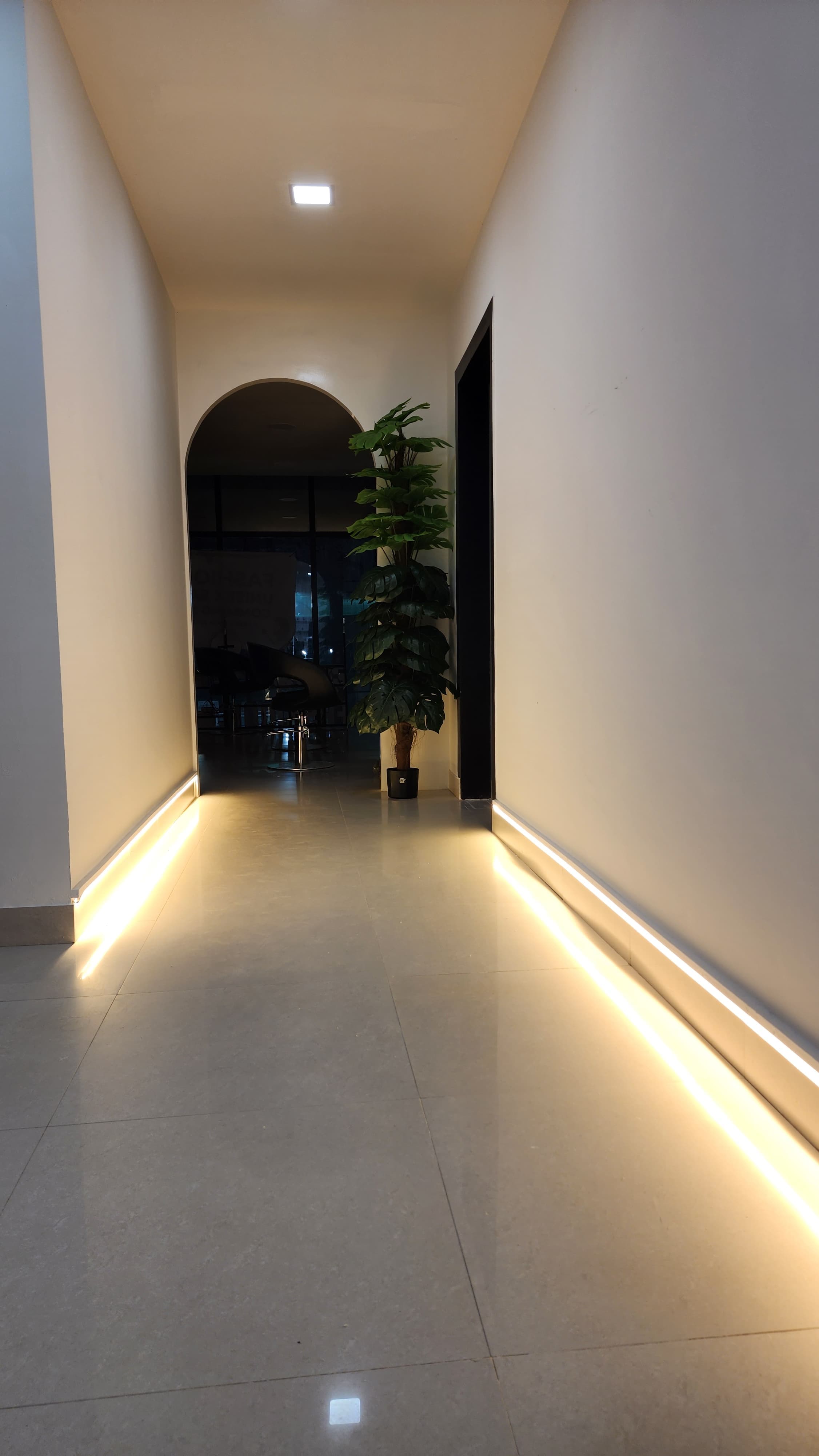 Salon corridor with warm LED strip lighting and arched doorway